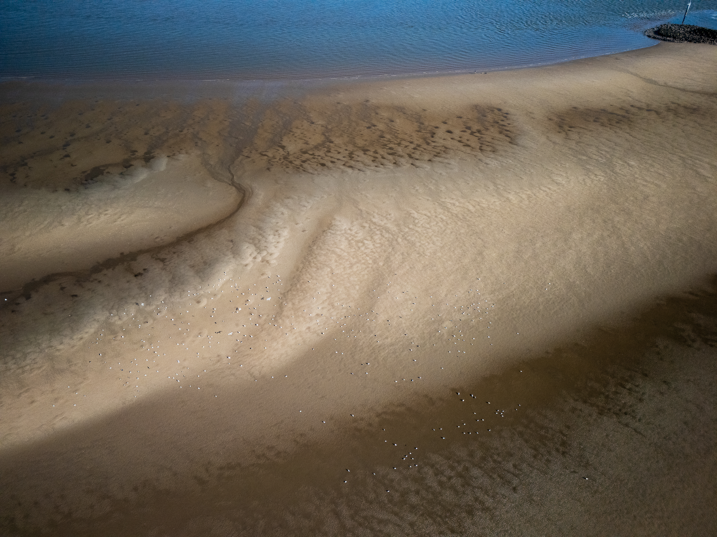 Drone view of a sandy beach in New Brighton, UK, early morning.